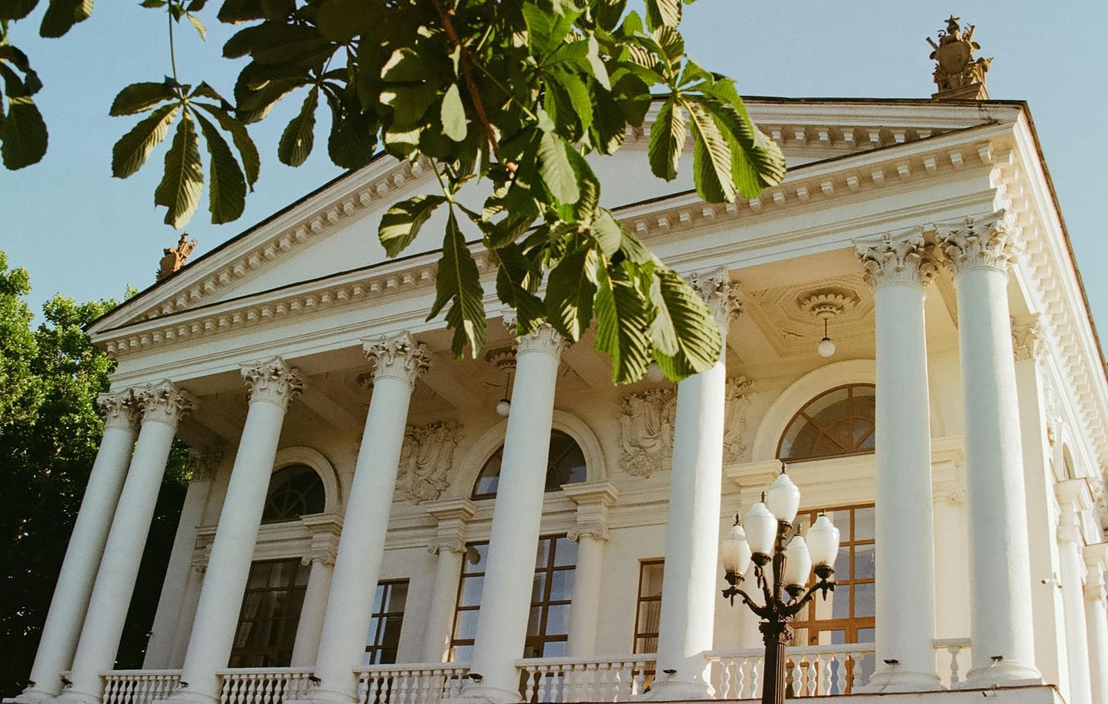 Front view of a white building with clear blue sky in the background.