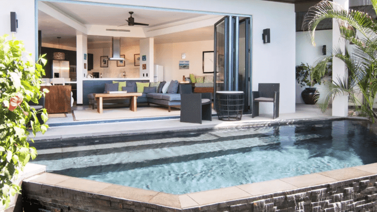 A luxurious villa features an outdoor living area with a private plunge pool and views of the ocean.