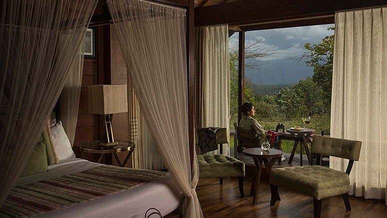 person looking out a window of Mountain View Log Hut