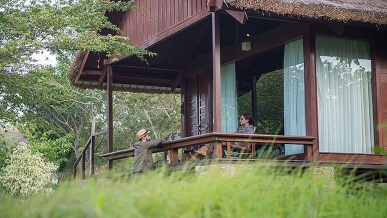 person sitting in the balcony of Mountain View Log Hut