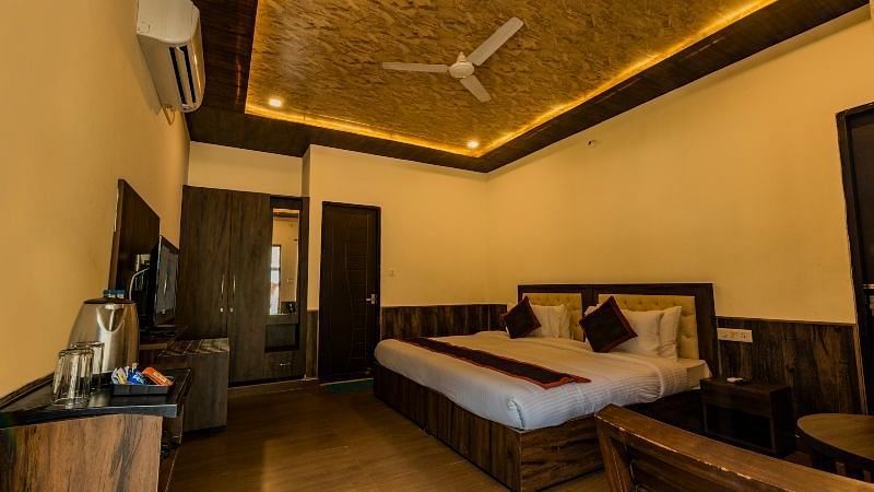 A Luxury Cottage with a large bed in front of the TV at DLS MJ River Resort, Rishikesh.