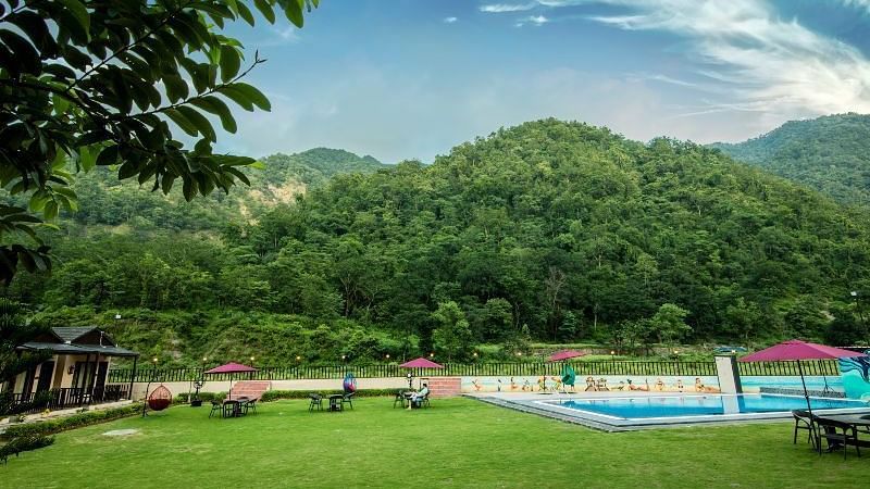View of the swimming pool during the day at DLS MJ River Resort, Rishikesh.