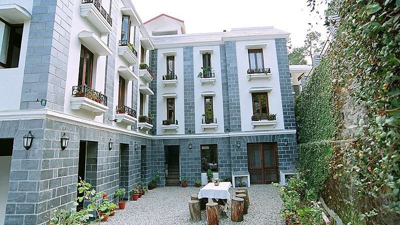 Colonial-style building with a courtyard and lush greenery.