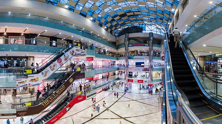 Modern multi-story shopping mall atrium with escalators in Gurgaon, India.