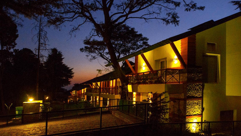 Illuminated facade of a modern building at dusk with exterior lights highlighting architectural features.