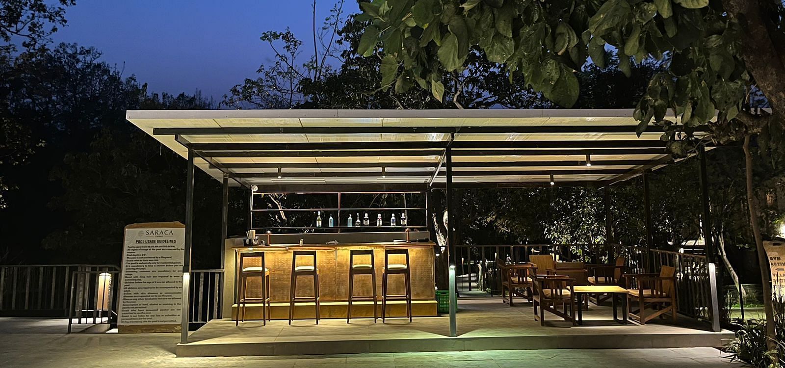 Outdoor seating arrangement at the Pool Bar at Saraca Resort & Spa Corbett during blue hour