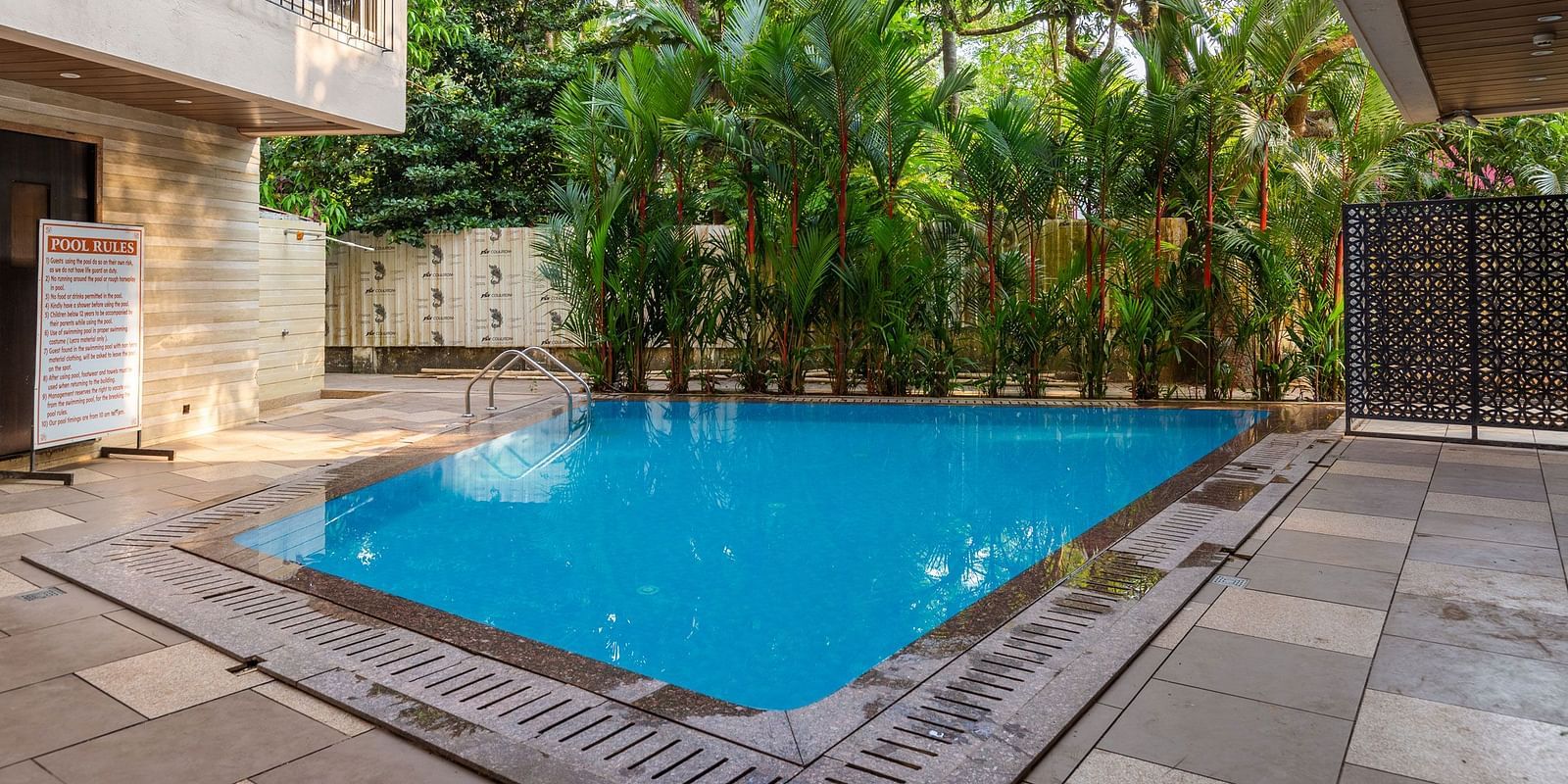 Image of a swimming pool with trees in the background at Calux Grand Inn, Calangute.