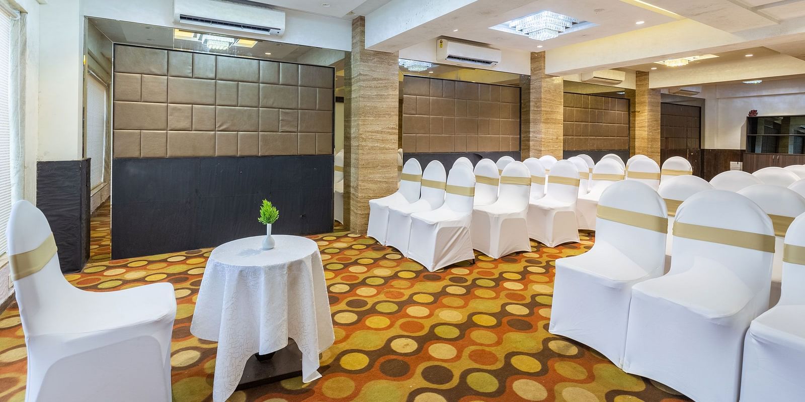 Image of a banquet hall with chairs neatly arranged at Calux Grand Inn, Calangute.