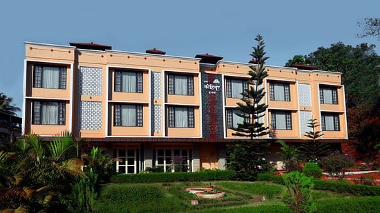 Facade of Kohinoor Highway Exterior surrounded by lush green lawn