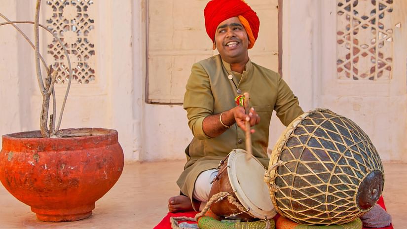 A man in a festive outfit playing a musical instrument