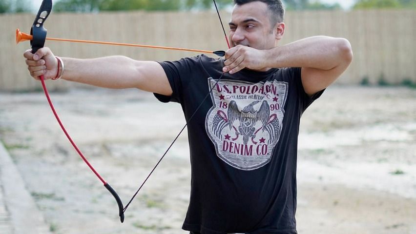 Man practising archery at inflated trampoline surrounded by trees at Themis Mudhouse - A Nature's Retreat Resort & Wellness