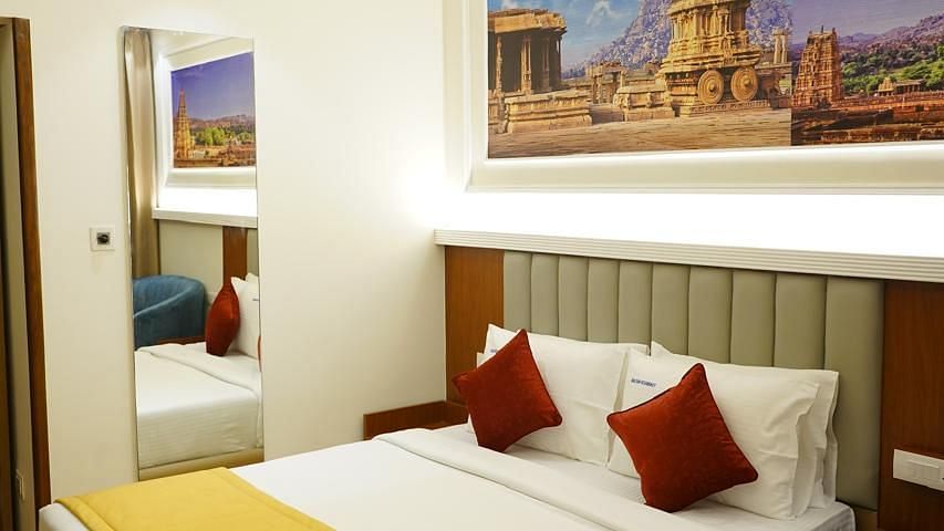 Room with a king bed, warm lighting, and artwork at Kalyan Residency Hotel, Tirupati – ideal for business or leisure guests.