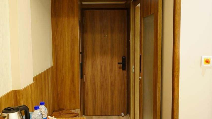 Entryway of the guest room at Kalyan Residency Hotel, Tirupati, featuring a tea/coffee station and modern design.