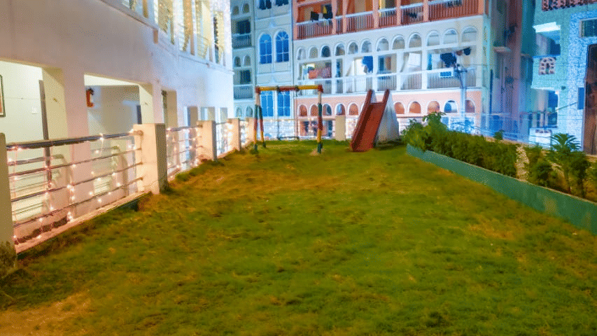 Exterior view of a brightly lit hotel building at night – Hotel Dolphin Puri