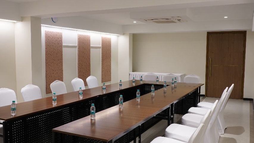 A conference room with a long dark table and white chairs, arranged for a productive meeting at Shilton Dee Cee.