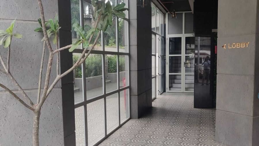 A corridor featuring potted plant and glass panels along the building's side at Indie Stays, BKC Kalina.