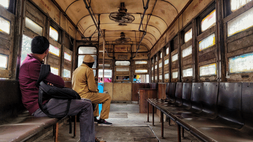 two people sitting in a monorail with wooden windows - Polo Floatel Kolkata