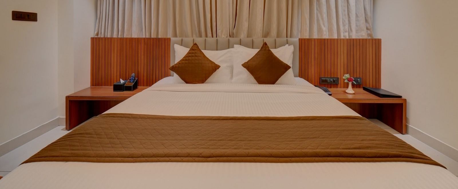Image of a room with a bed with side tables on both sides at Hari Govindas, Siddappa Square.