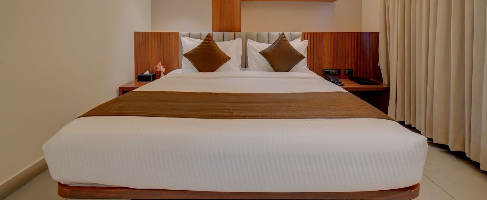 An image of a room at Hari Govindas, Siddappa Square, featuring a bed with a window on the side.