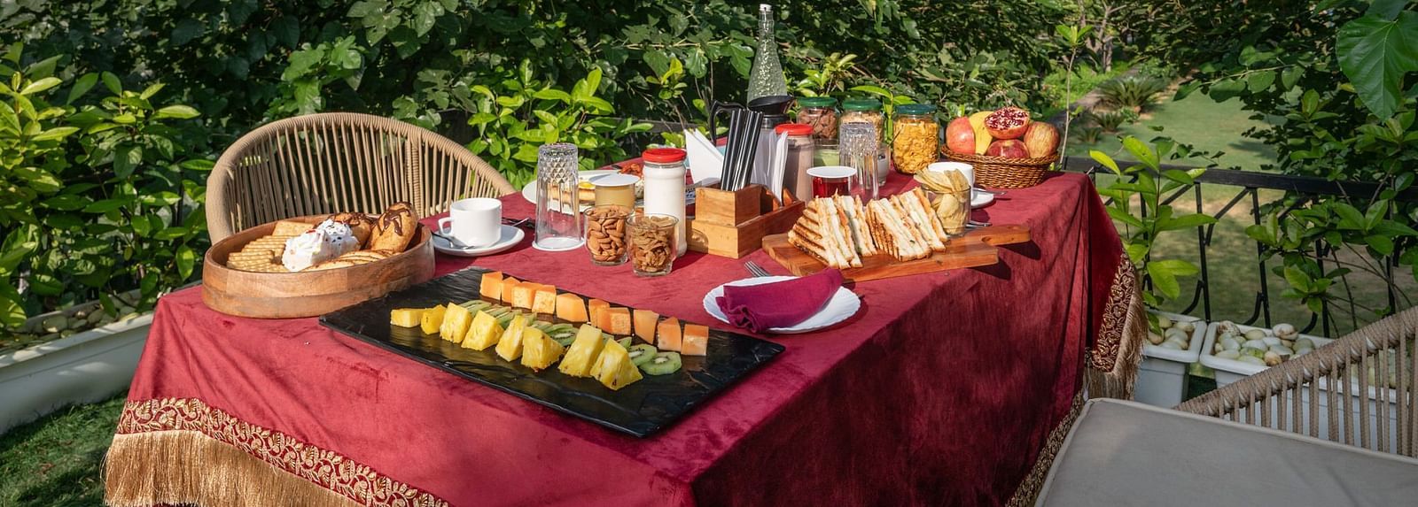 A table filled with food set in an outdoor space surrounded by lush plants at Valley by Grassfield.