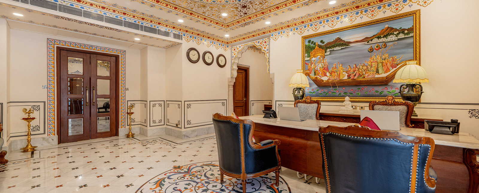 back side of the reception area with a wooden door in the corner opening to the lobby area - Brij Castle, Jaipur