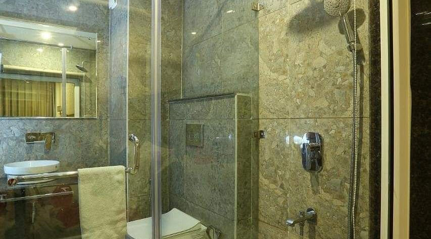 image of a modern bathroom with transparent glass doors at the family room - ZENQ SIGNATURE INN, MCLEODGANJ