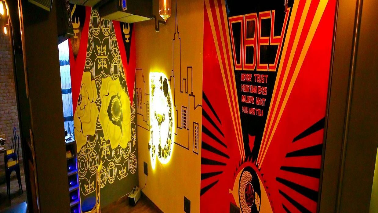 A vibrant wall mural complemented by retro-style lighting in a chic dining area - Hotel Moti Palace