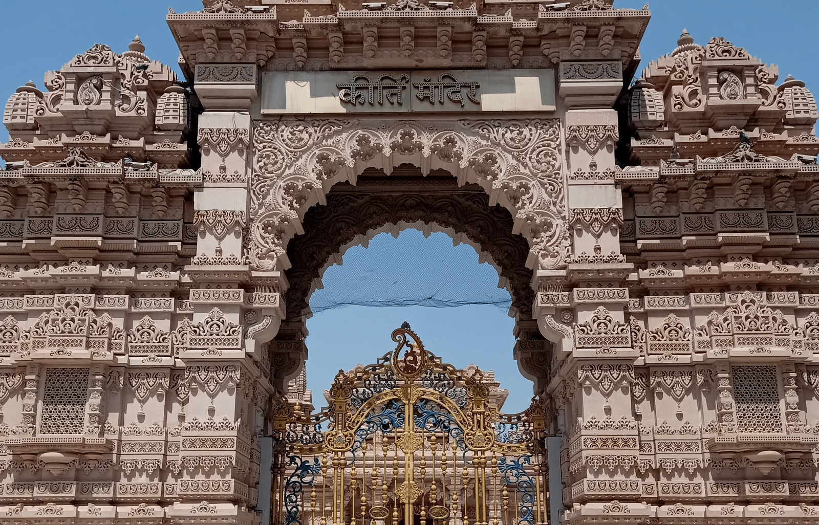 Getway of Keerti Temple featuring ornated gate and carvings on the wall