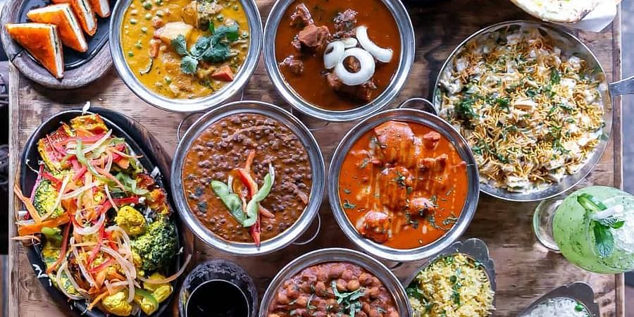alt-text An overhead shot of various food items served in dishes and placed on a wooden table Sun Park Hotel & Banquet, Chandigarh - Zirakpur