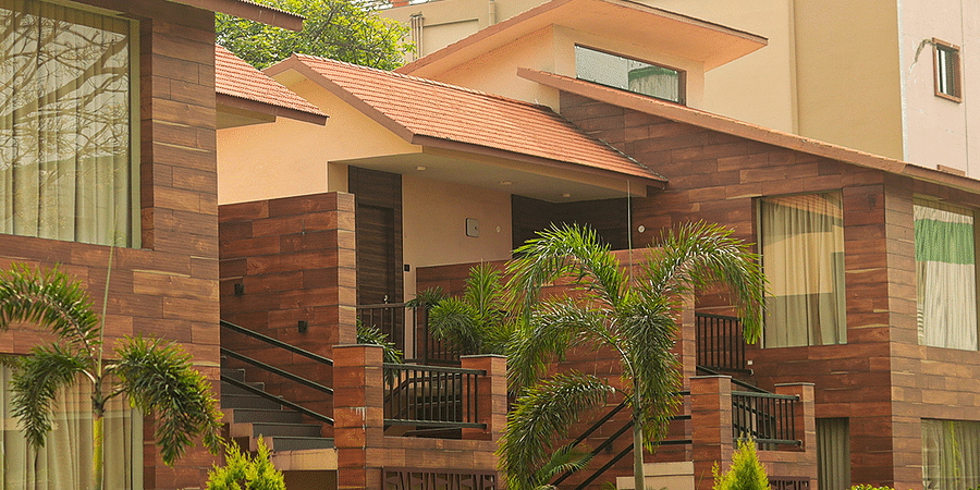 alt-text Elegant Resort with Red Brick Architecture, Lush Green Surroundings, and Blue Sky