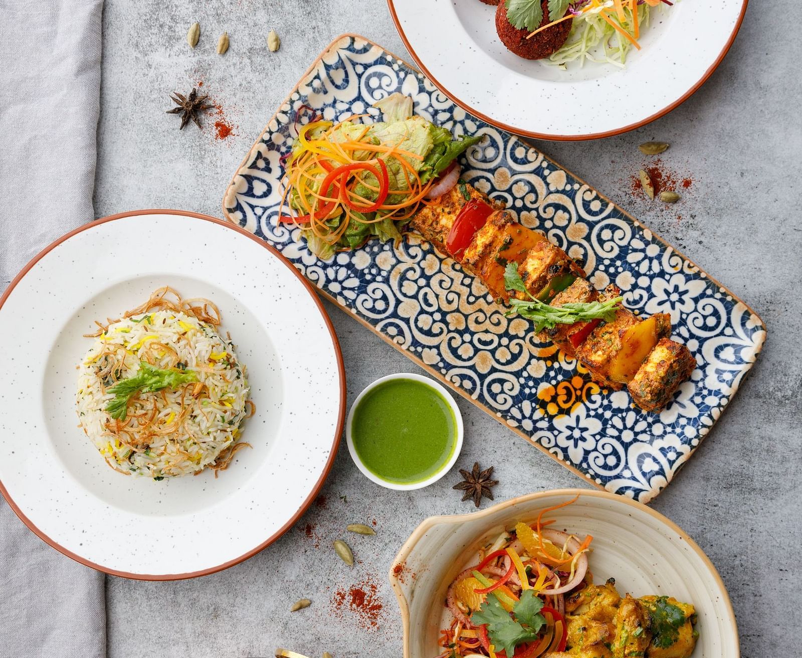 Assorted Indian dishes including rice, kebabs, and curry