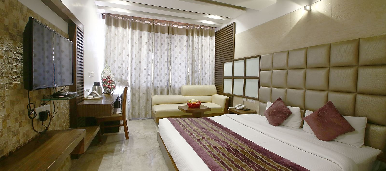  A spacious and well-lit hotel room with elegant interiors, a comfortable bed, and modern amenities - Hotel Emerald, Chandigarh