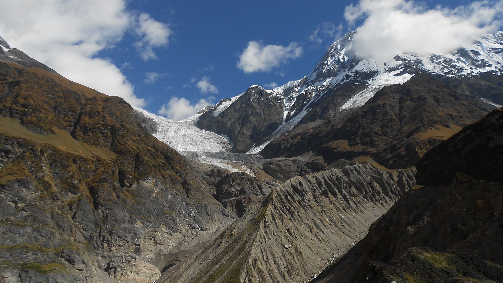 Majestic mountain range with snow-capped peaks, towering over a valley.