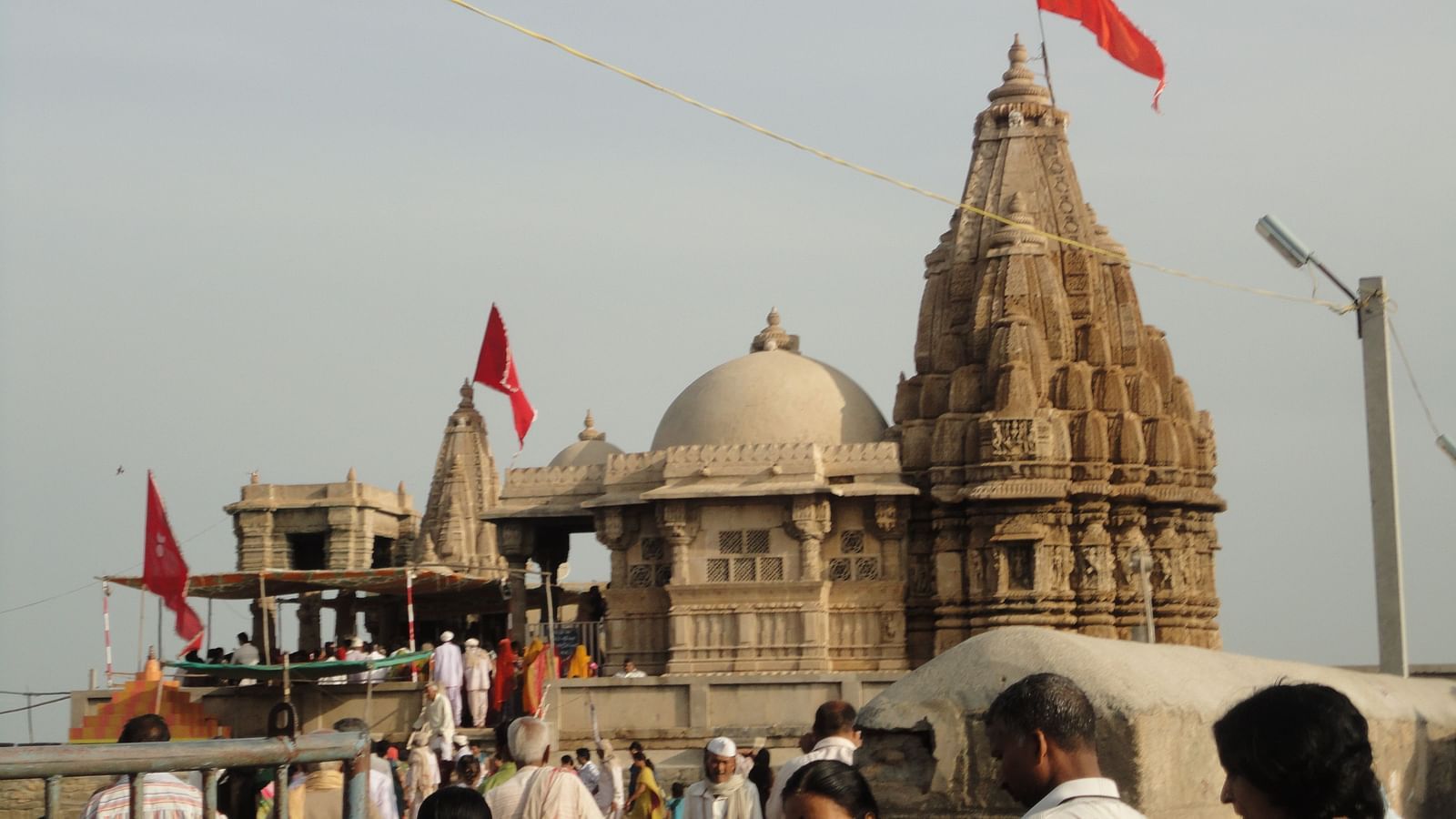 Temple with intricate carvings and a large crowd of devotees.