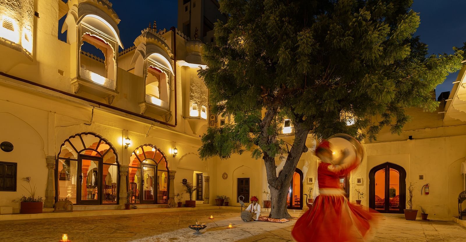 A dancer performing in the open courtyard at The Umaid Vilas, Jaipur during blue hour
