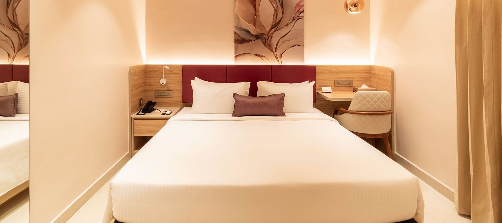 King-sized bed with wall art in The Executive Rooms at TGI Livancia The Sojourn, Bangalore.