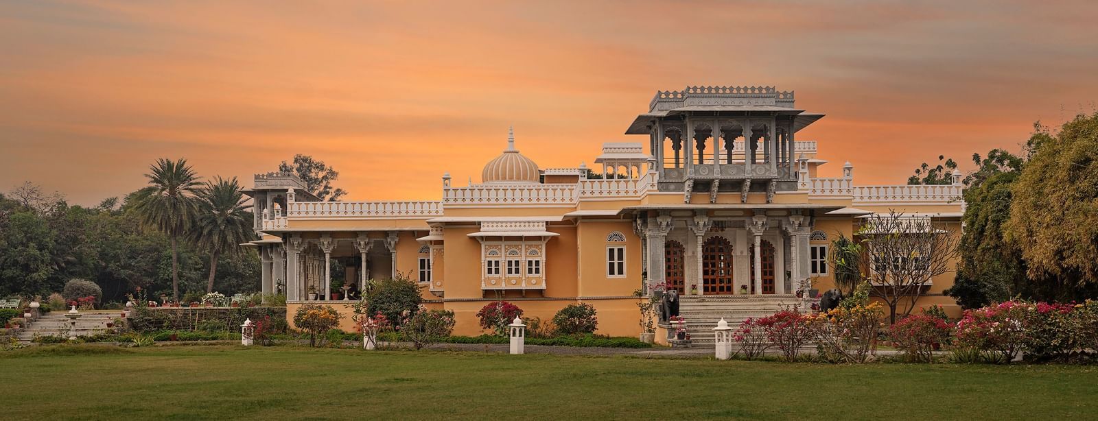 facade image of dev shree, deogarh with a sunset in the background