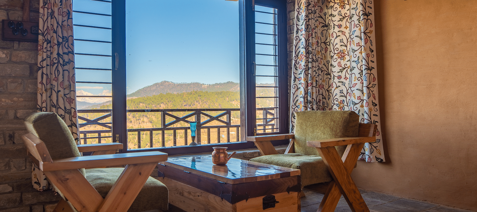 Cosy seating area by a large window overlooking a green valley and distant hills. - Blusalzz Homes The Himalayan Bungalow, Almora