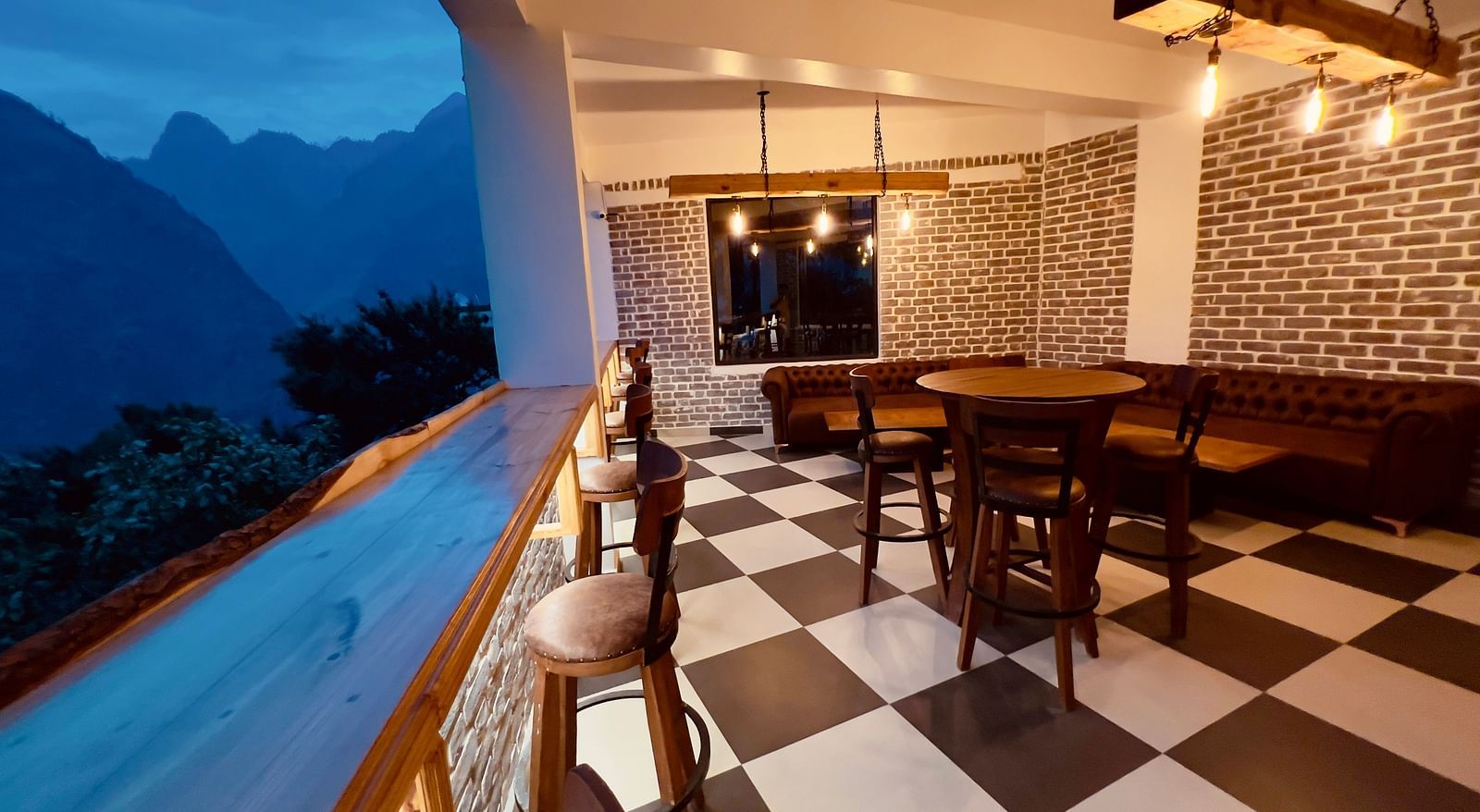 image of the alpenrose restaurant with black and white tiles overlooking at the amzing mountain views in the late evening - the tattva boutique resort 