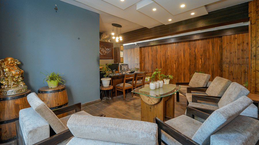 The reception and lobby area of DLS Whispering Winds with sofa set, table, chairs, and a reception desk