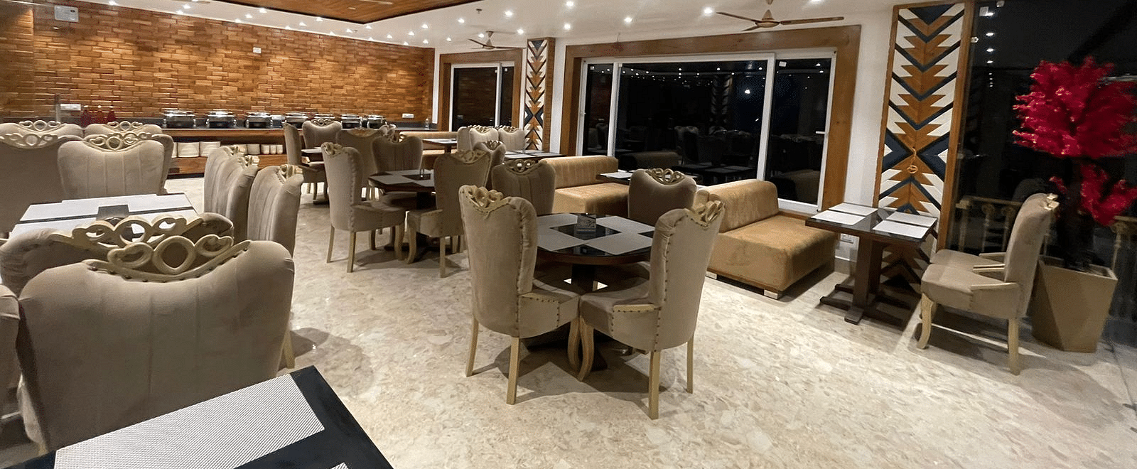 Dining area with comfortable chairs around tables at Rainbow Restaurant at DLS Ark Holiday Inn, Banikhet.
