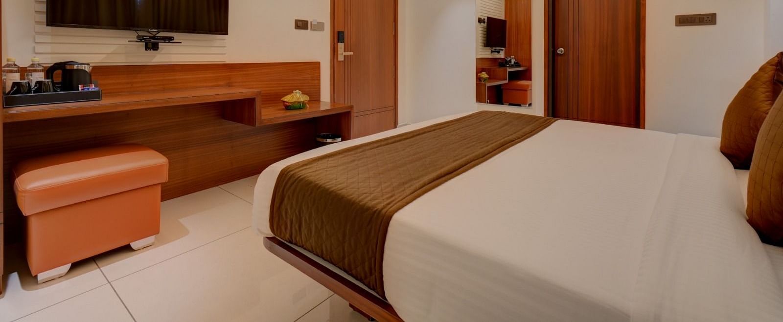 A side view of a room featuring a bed with a television positioned in front at Hari Govindas, Siddappa Square.