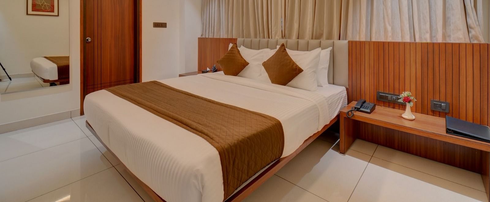 Image of a room with a bed and a door on the side at Hari Govindas, Siddappa Square.