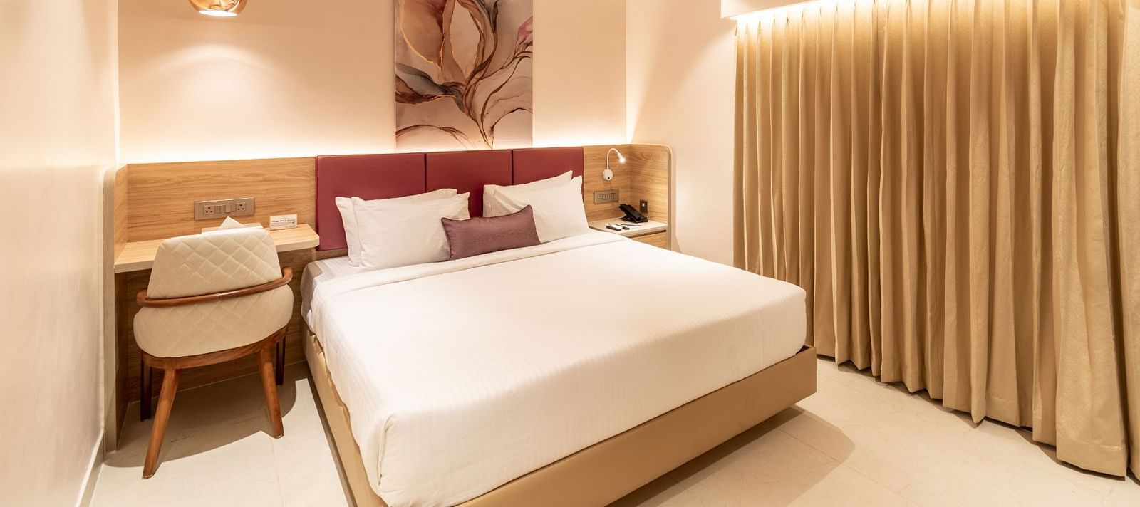Bedroom with large windows in The Executive Room at TGI Livancia The Sojourn, Bangalore.