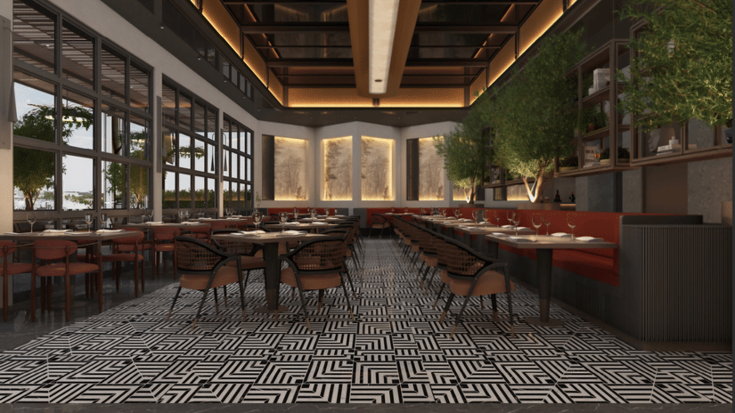 Dining area at Tulip Inn Bidar featuring multiple tables and chairs, booth seating along the wall, large windows, indoor plants, and patterned flooring.