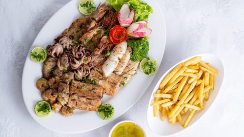 A plate with food and another bowl with fries is arranged.