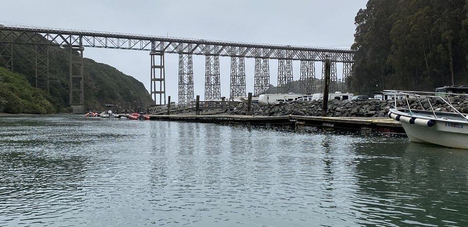 A lake with a bridge in the middle that connects two mountains