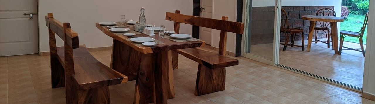 Indoor dining space with rustic wooden furniture and bright lighting at The Conservancy Bungalow.