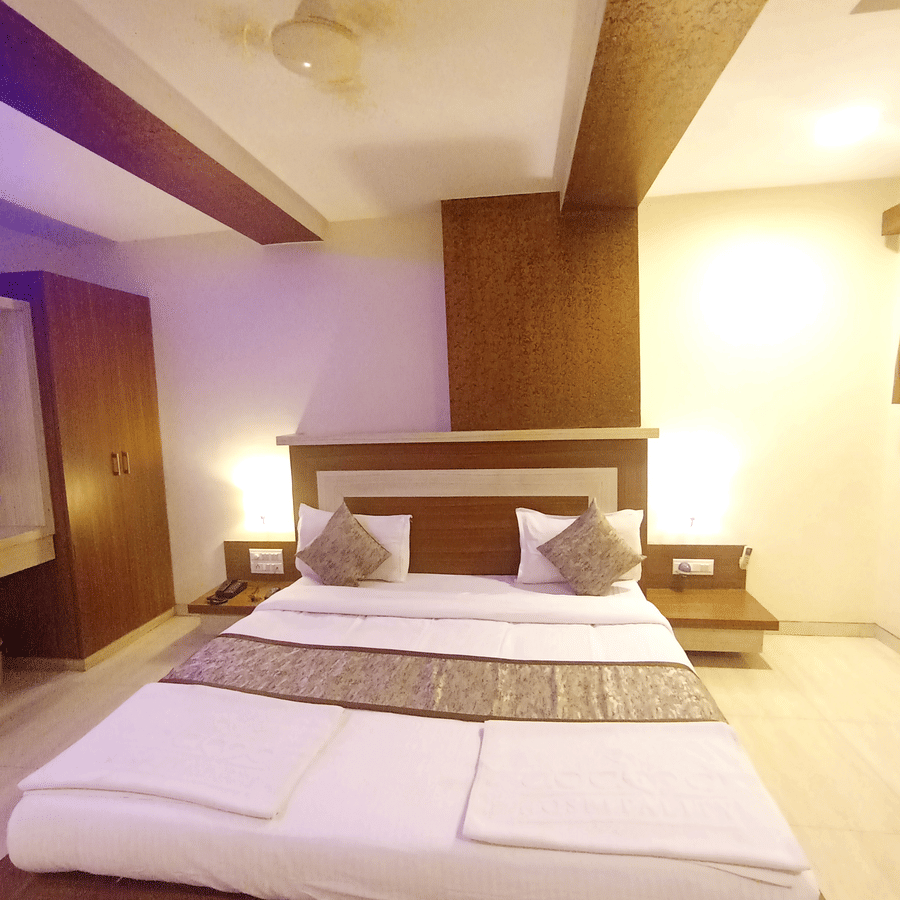 Vertical shot of the suite room featuring a double bed, wood paneled accents, and tile flooring.