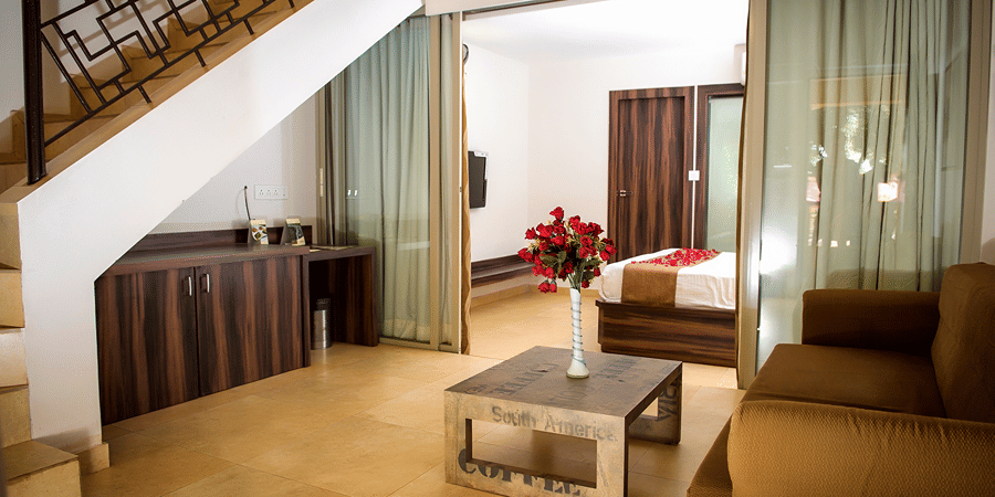 Deluxe villa bedroom living  room interior featuring a sofa and coffee table - Adamo Resort Matheran.